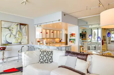 a living room with a white couch and a kitchen at Lake Tahoe Gem with Furnished Deck and Water Views! in Incline Village