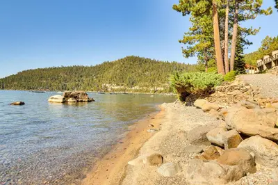 a beach with rocks and trees in the water at Lake Tahoe Gem with Furnished Deck and Water Views! in Incline Village