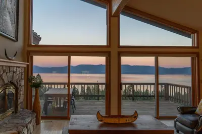 a living room with a large window with a view of the ocean at Sierra Lake View at Rubicon by Tahoe Getaways - 3 BR, Panoramic Lake Views, Private Hot Tub & Private beach! in Tahoma