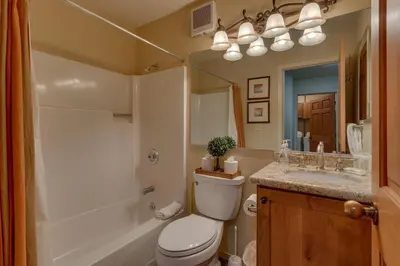 a bathroom with a toilet and a sink and a mirror at Rocky Point #93 3BR Townhome in Northstar - Shuttle to Slopes - HOA Amenities in Truckee