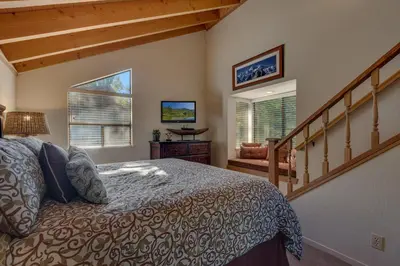 a bedroom with a large bed and a staircase at Rocky Point #93 3BR Townhome in Northstar - Shuttle to Slopes - HOA Amenities in Truckee