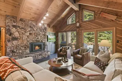 a living room with a stone wall at Sleeping Bear Lodge- Remodeled 3BR Cabin- Fireplace- Ski Shuttle- Pet-Friendly in Truckee