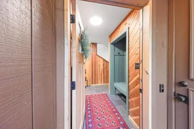 a hallway of a house with a red rug at Sleeping Bear Lodge- Remodeled 3BR Cabin- Fireplace- Ski Shuttle- Pet-Friendly in Truckee