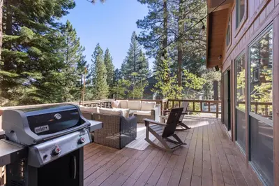 a grill on the deck of a house at Sleeping Bear Lodge- Remodeled 3BR Cabin- Fireplace- Ski Shuttle- Pet-Friendly in Truckee