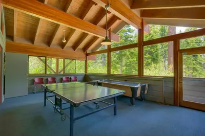 a room with two ping pong tables and chairs at Sleeping Bear Lodge- Remodeled 3BR Cabin- Fireplace- Ski Shuttle- Pet-Friendly in Truckee