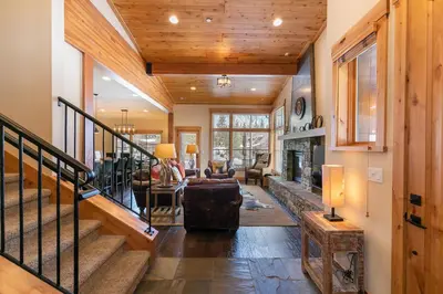 a living room with a staircase and a fireplace at Trestlewood Lodge at Schaffers Mill - Gorgeous 3 BR w Golf Course Views - Extended Stays Welcome! in Truckee