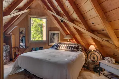 a bedroom with a large bed in a attic at Falcon's Rest - Ski and Summer Cabin in The Heart of North Lake Tahoe- Gas Fireplace in Carnelian Bay