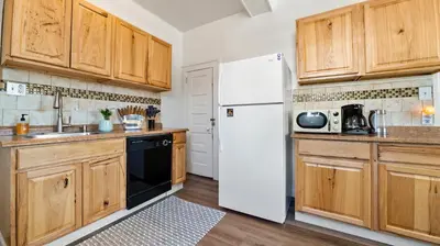 a kitchen with wooden cabinets and a white refrigerator at Midtown Flight Deck: 2BR Gem in Reno