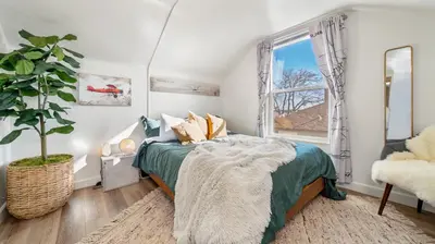 a bedroom with a bed and a potted plant at Midtown Flight Deck: 2BR Gem in Reno