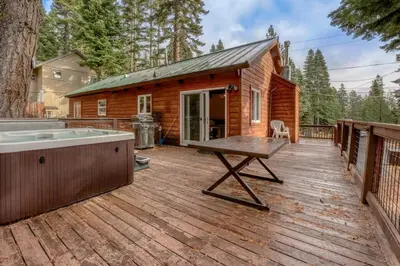 a log cabin with a hot tub on a wooden deck at Stylish 3BR Near Trails w Hot Tub in Tahoe City