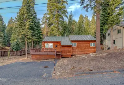 a log cabin with a deck in the woods at Stylish 3BR Near Trails w Hot Tub in Tahoe City