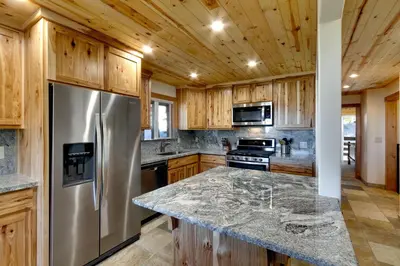 a kitchen with a stainless steel refrigerator and wooden cabinets at Tall Pine Chalet in Stateline