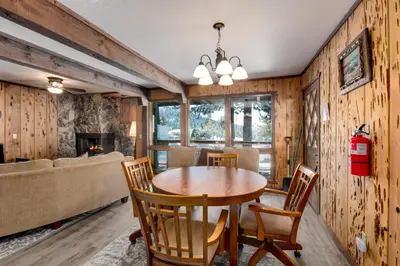 a dining room with a table and chairs and a fireplace at Snowflake Chalet in Stateline