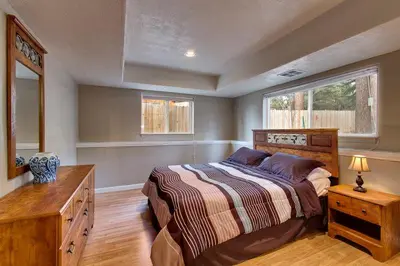 a bedroom with a bed and a dresser and a window at Sequoia Chalet in Stateline