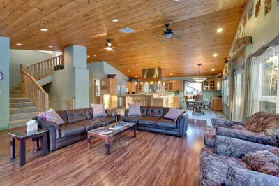 a living room with two couches and a kitchen at Sequoia Chalet in Stateline