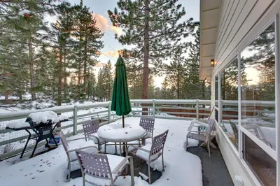 a patio with a table and chairs in the snow at Sequoia Chalet in Stateline