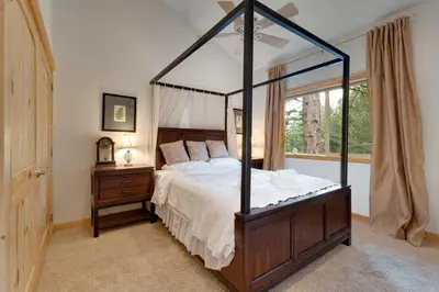 a bedroom with a canopy bed and a window at Lodgepole Pine Chalet in South Lake Tahoe