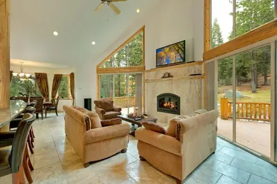 a living room with chairs and a fireplace at Lodgepole Pine Chalet in South Lake Tahoe