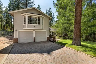 a house with two garage doors and a tree at Panhandle House in South Lake Tahoe