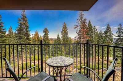 a balcony with a table and chairs on a fence at Stylish 2BD in Carnelian Bay in Carnelian Bay