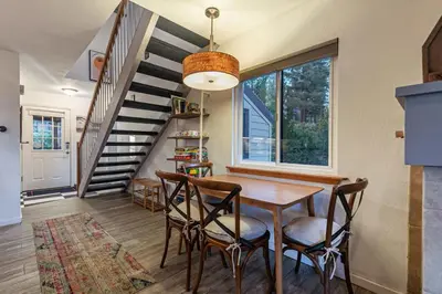 a dining room with a table and chairs and a staircase at Stylish 2BD in Carnelian Bay in Carnelian Bay