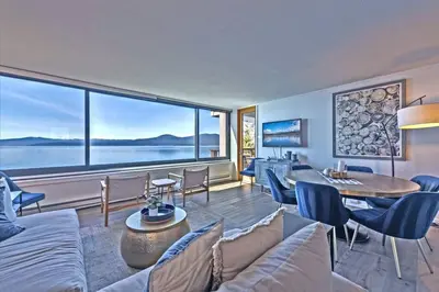 a living room with a couch and a large window at VIP Lakefront Condo Amazing Views Pool Pickleball Excellent Location Balcony BBQ in Kings Beach