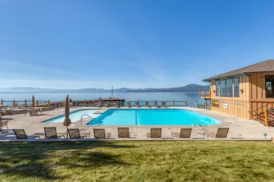 a large swimming pool with chairs and a house at VIP Lakefront Condo Amazing Views Pool Pickleball Excellent Location Balcony BBQ in Kings Beach