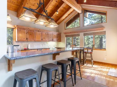 a kitchen with a large counter with stools in it at Tahoe Pines, enjoy the outdoors this home has to offers in Incline Village