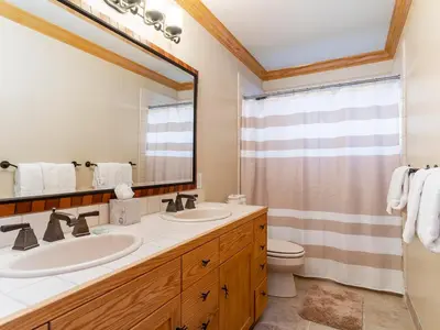 a bathroom with two sinks and a toilet and a mirror at Tahoe Pines, enjoy the outdoors this home has to offers in Incline Village