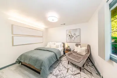 a bedroom with a bed and a chair and a window at Starry Night Cabin at Sky Ranch in Oakhurst