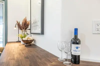 a bottle of wine sitting on a table with two wine glasses at Starry Night Cabin at Sky Ranch in Oakhurst