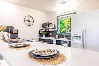 a kitchen with two plates and wine glasses on a counter at Starry Night Cabin at Sky Ranch in Oakhurst