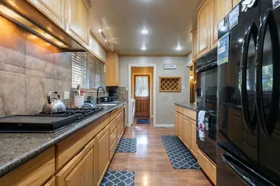 a kitchen with wooden cabinets and a stove top oven at Serene 5BDR Near Beach and Forest Trails in Carnelian Bay