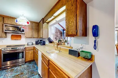 a kitchen with wooden cabinets and a sink at Antler & Pine in South Lake Tahoe