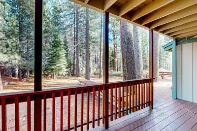 a screened in porch with a view of the woods at Antler & Pine in South Lake Tahoe