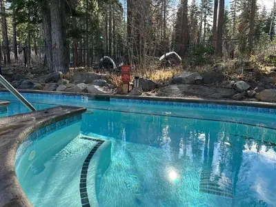 a swimming pool with blue water in a yard at Lofty Retreat, Condo in Northstar in Truckee