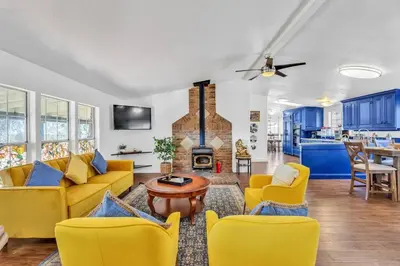 a living room with yellow furniture and a fireplace at Cozy Cabin on 10 acres in Pilot Hill