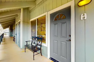 a porch with a black chair and a door at Stagecoach Ski Condo in Stateline