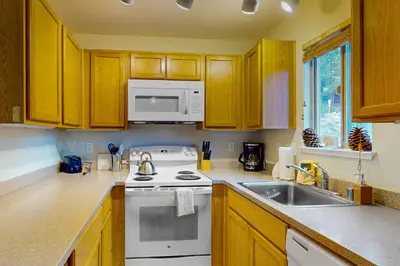 a kitchen with a white stove top oven next to a sink at Stagecoach Ski Condo in Stateline