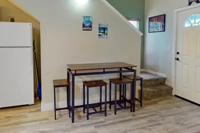 a kitchen with a table and stools and a refrigerator at Stagecoach Ski Condo in Stateline
