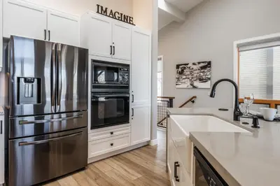 a kitchen with a stainless steel refrigerator and white cabinets at Snowcreek V 972 in Mammoth Lakes