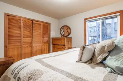 a bedroom with a bed with a dresser and a window at North Shore - Pinetree Paradise in Tahoe Vista