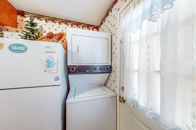 a kitchen with a refrigerator and a window at Pine Needle Nook in Kings Beach