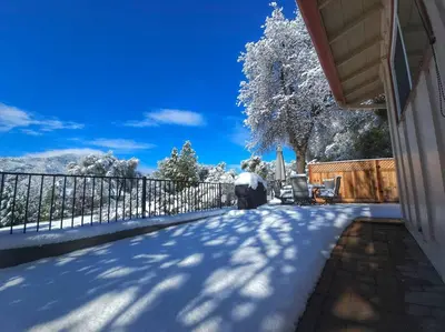 a snow covered driveway of a house with a fence at Peaceful Yosemite Retreat-King Suite-Pet Friendly in Oakhurst