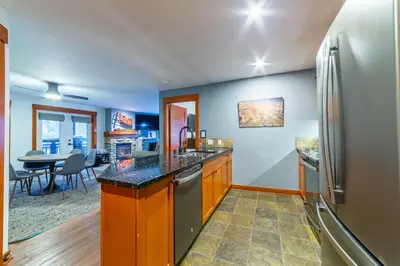 a kitchen with a refrigerator and a table at Luxurious Remodeled Village Oasis in Mammoth Lakes