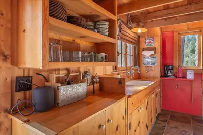 a kitchen with wooden cabinets and a counter top at Coziest Cabin in Tahoe w Stone Fireplace Comfy Beds Close to Slopes & Lake in Carnelian Bay