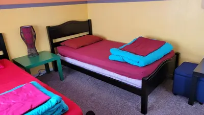 a room with two beds and a table at Yosemite International Hostel in Groveland