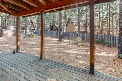a wooden deck with a house in the background at High Meadow Hideaway in South Lake Tahoe