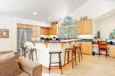 a kitchen with a bar with stools and a couch at High Meadow Hideaway in South Lake Tahoe