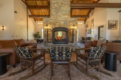 a living room with a fireplace and a table and chairs at Firefall Ranch Yosemite in Groveland